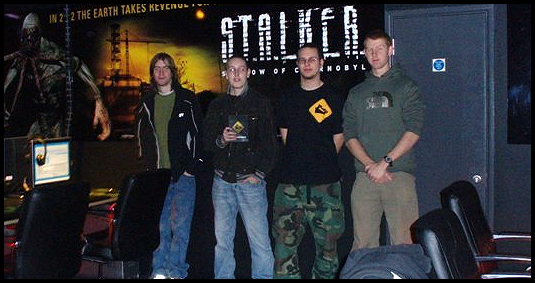 Photo of Sir. members in front of the STALKER logo